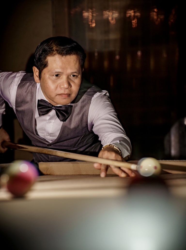 Man playing billiards in a bar setting